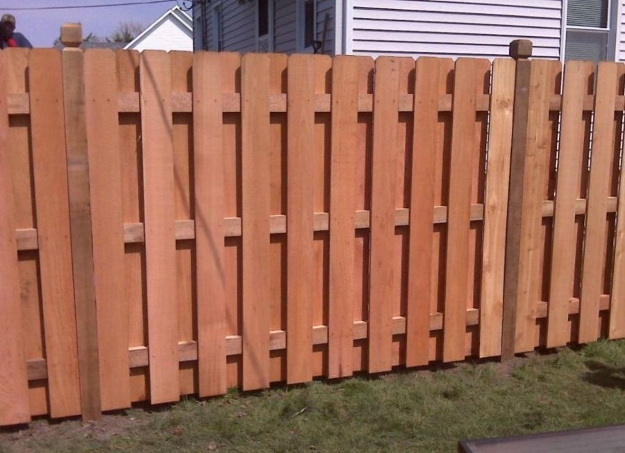 Deaf fence with a staggered wooden picket fence