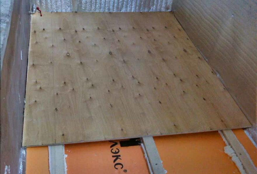 Montering av kryssfiner på gulvet på en varm balkong