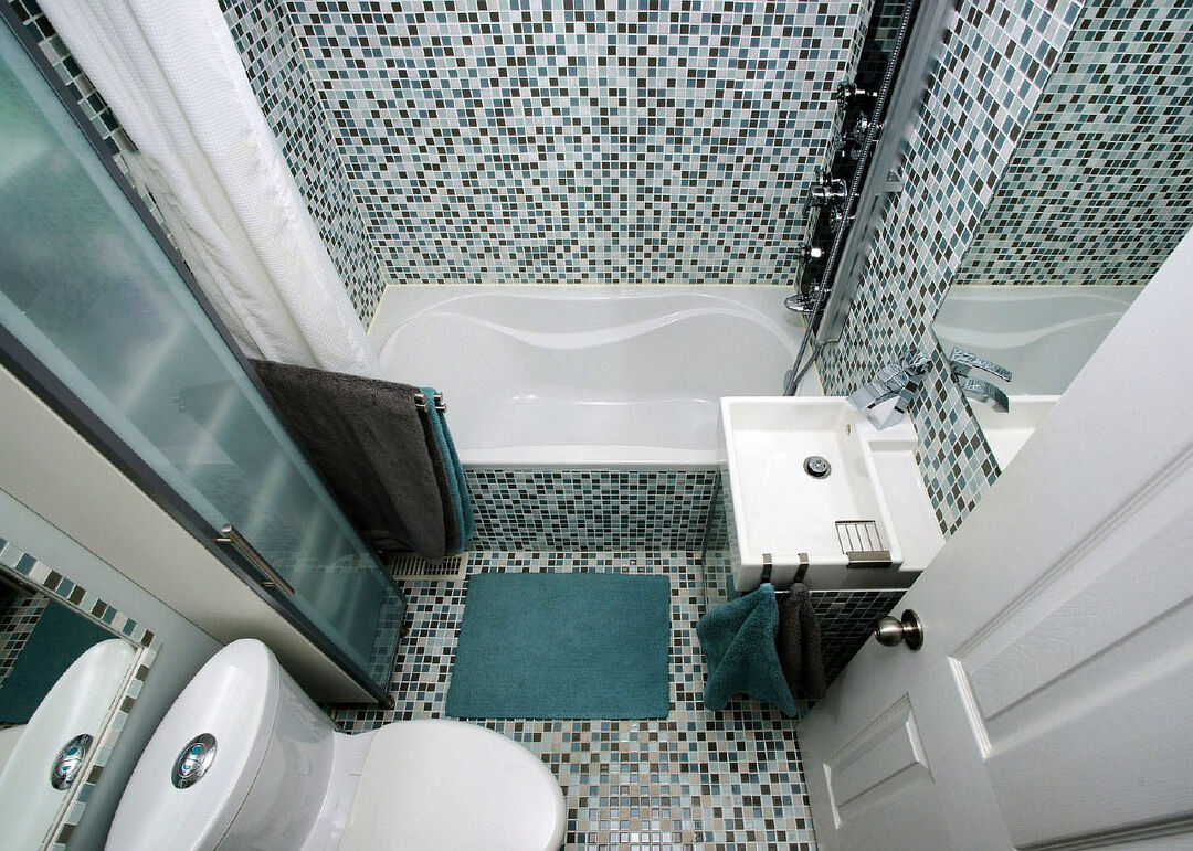 Mustavalkoinen mosaiikki kylpyhuoneessa, jossa on wc