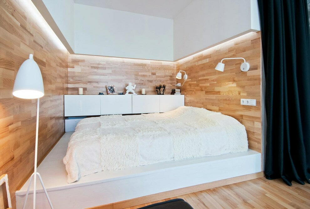 Pieni huone, jossa on sänky betonista valmistetulla korokkeella