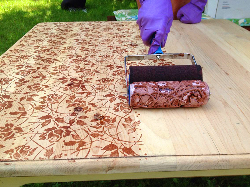 Creando patrones en la mesa con un rodillo de pintura de esténcil