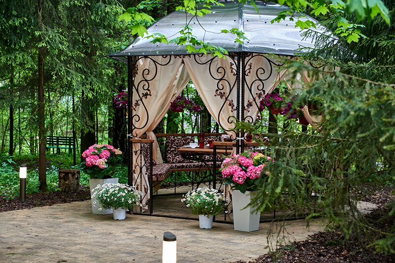 Decor of a metal gazebo with flowering plants