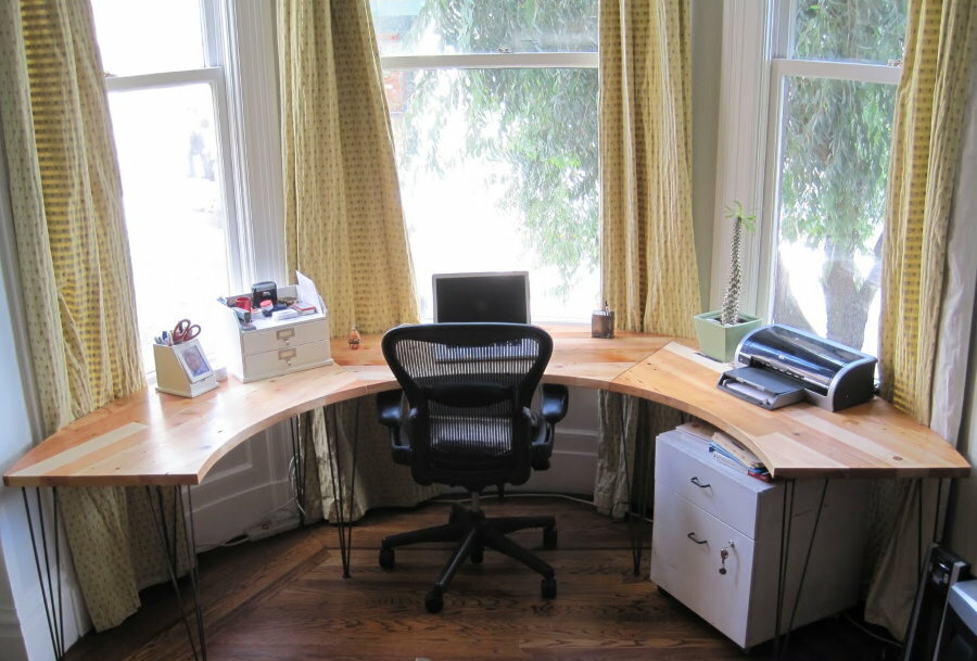 Arrangement of a workplace in a living room with a bay window