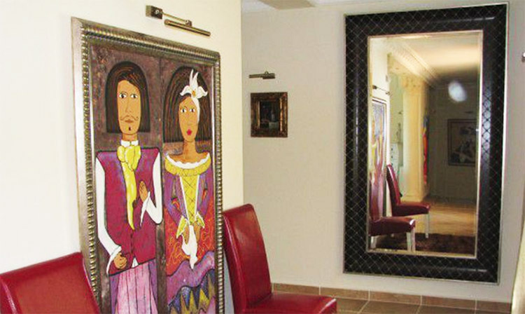 En stor spegel i en ram täckt med äkta läder kompletterar vardagsrummets design