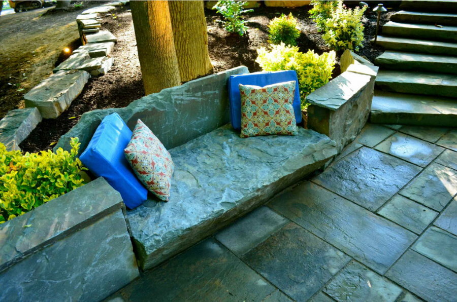 Almohadas suaves en un banco de piedra en el jardín