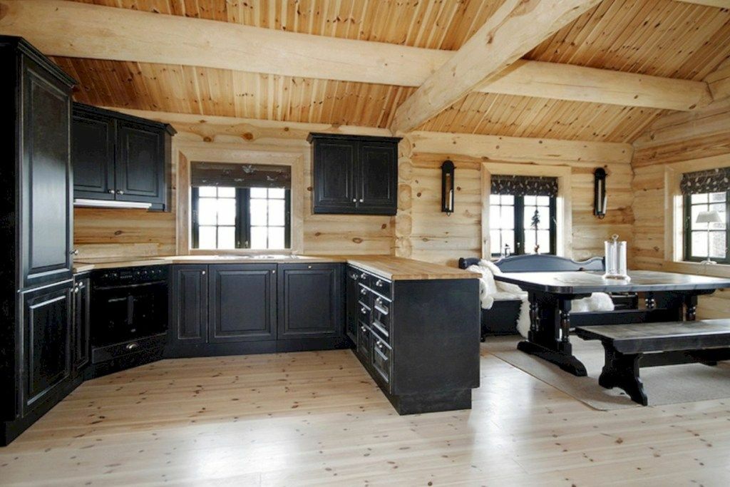 Muebles oscuros en la cocina-sala de estar de una casa de madera.