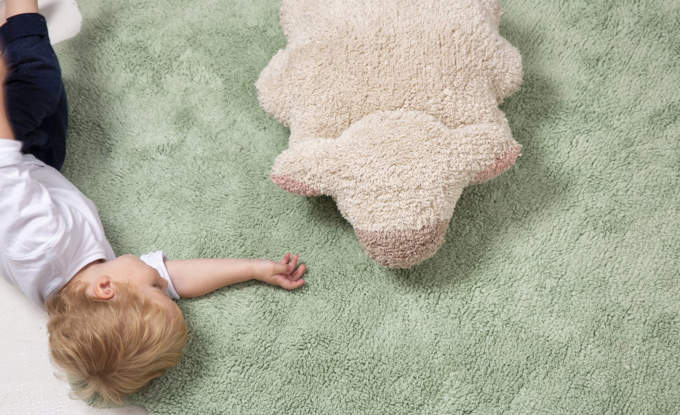 Ett barn i förskoleåldern på den mjuka mattor