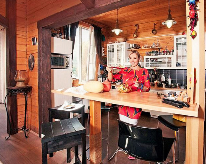 Kuhinjo od dnevne sobe ločuje točilni pult, blizu katerega so postavili visoke črne stole