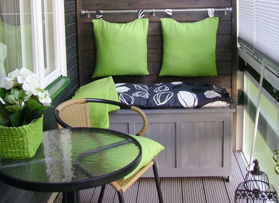 Table with a sofa on the balcony with PVC windows