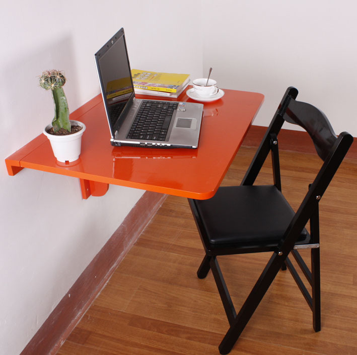 Table suspendue rouge pour travailler avec un ordinateur portable sur le balcon