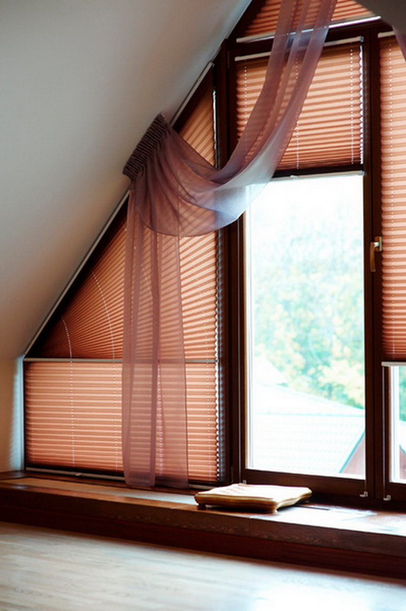 Pink paper curtains on the window in the attic of a private house