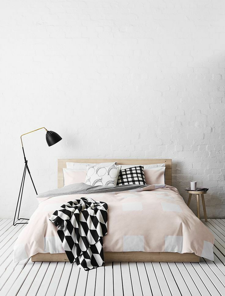 Niskie łóżko na drewnianej podłodze sypialni