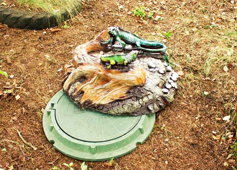 Você também pode deixar um elemento decorativo na tampa da escotilha - algo como um poço ou uma escultura de jardim