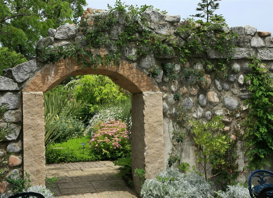 Arco in pietra all'ingresso del giardino in stile paesaggistico