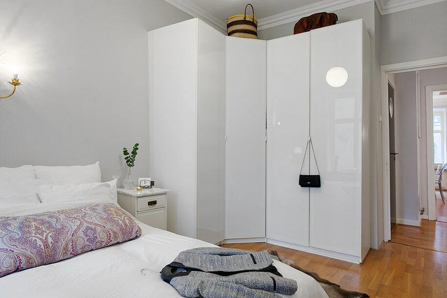Modern bir yatak odasında beyaz köşe gardırop
