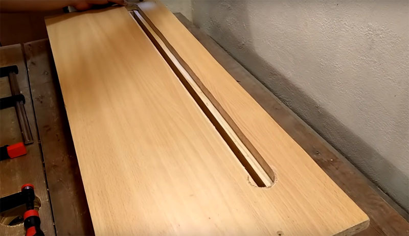 Tako medsebojno povezane kose lesa je treba dodatno pritrditi na stojalo širine približno 40 cm, v katerem je ob strani tudi vzdolžna reža