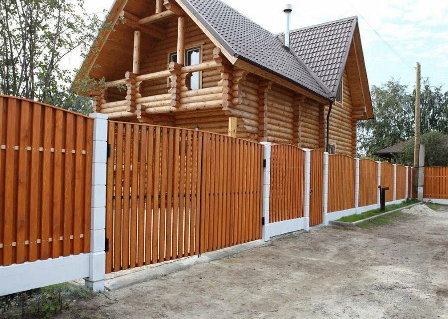 Wooden picket fence in front of the log house