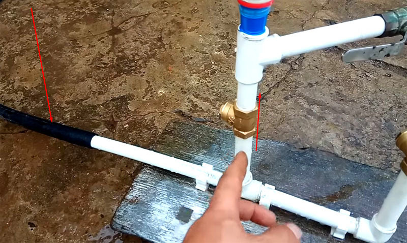 Water flows through a black hose to a non-return valve pointing upwards
