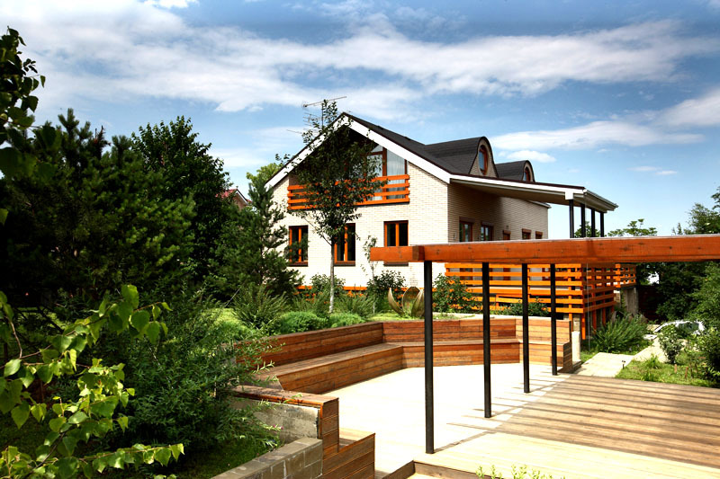 Tarp namų buvo įrengta patogi poilsio zona su medine terasa draugiškiems susibūrimams šiltuoju metų laiku