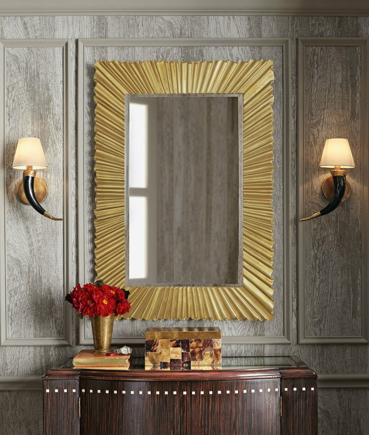 Speil i en gyllen ramme over kommoden i gangen