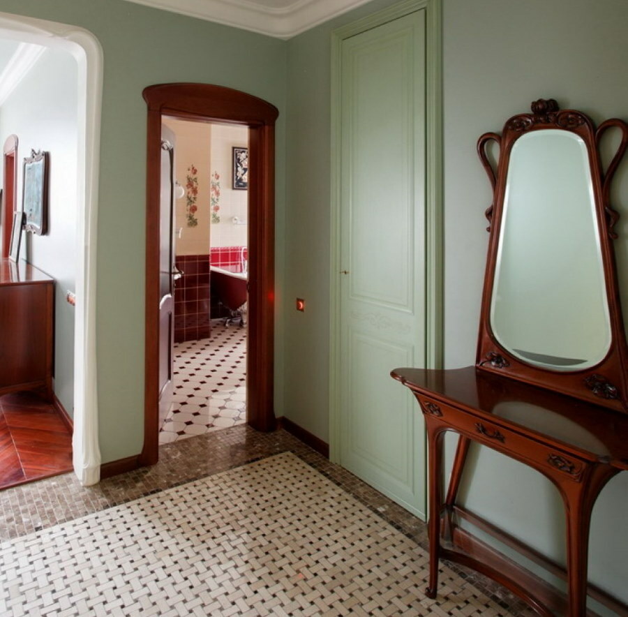 Stalas su veidrodžiu mediniame rėme Art Nouveau stiliaus koridoriuje
