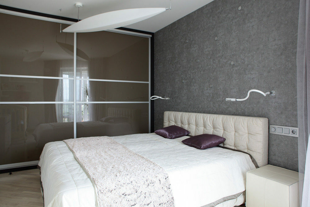 Baltos rozetės ant pilkos sienos miegamajame