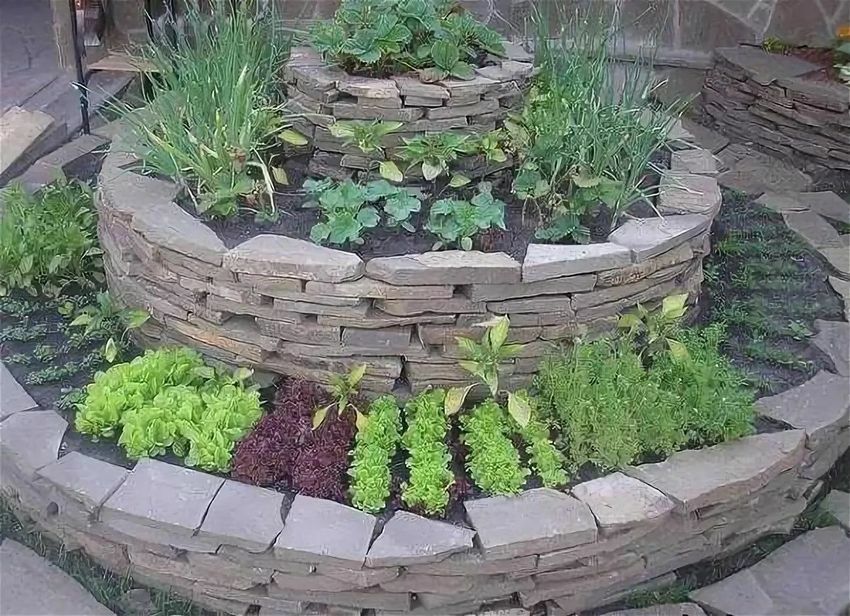 Planting plants in a flower bed made of natural stone