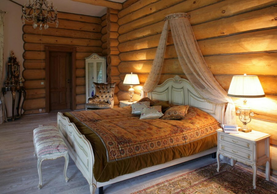 Wide bed in the bedroom of a log house