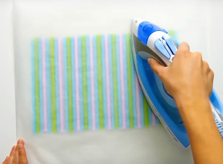 Cubra las pajitas con una segunda hoja de papel y trabaje sobre la parte superior con una plancha caliente para que se derrita.