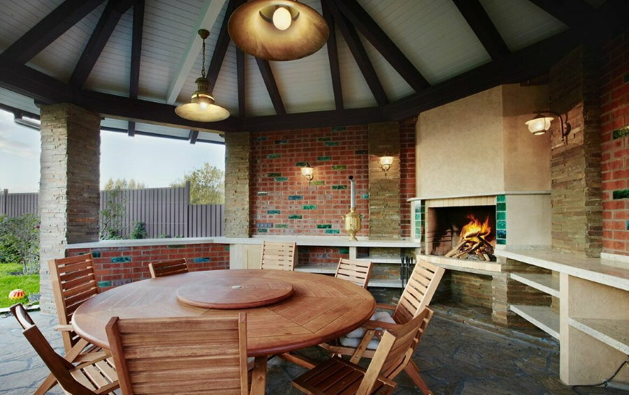Round table in a brick gazebo with a stove