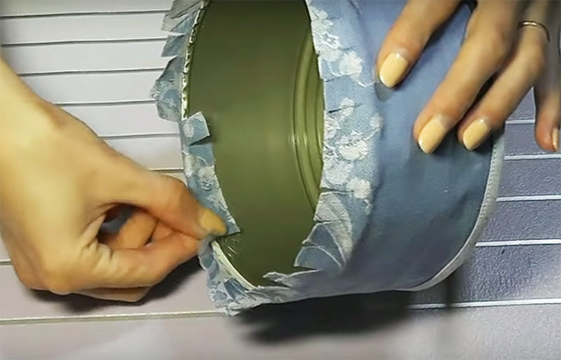 Wrap the edges of the fabric and glue it with hot glue to the rim of the can