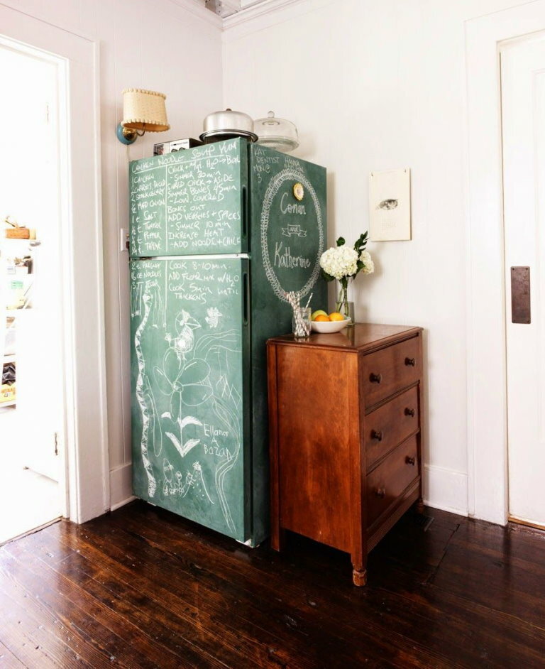 Réfrigérateur peint à la craie près de la commode dans le couloir
