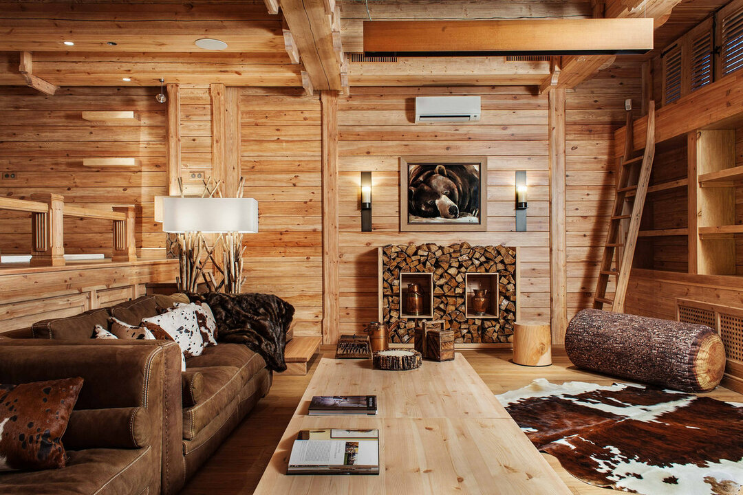 Wohnzimmer in einem Holzhaus: Kamin und andere Attribute im Inneren des Raumes, Foto