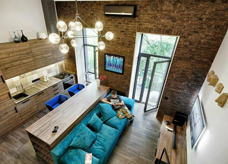 ספה בצבע טורקיז בדירת סטודיו בסגנון לופט