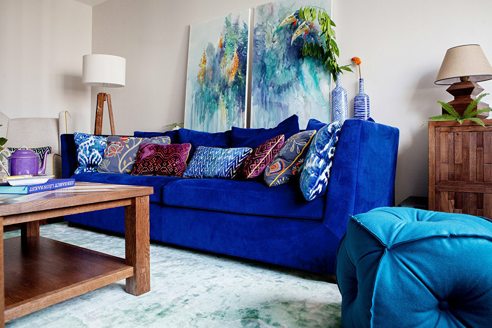 Abstract paintings over a sofa with ultramarine upholstery
