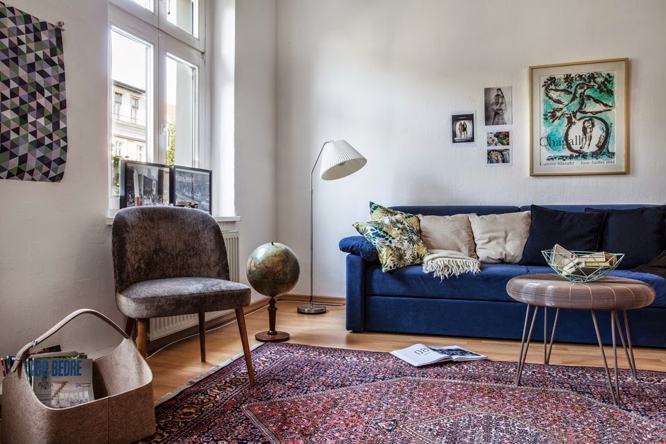 Design av ett ljust vardagsrum med en blå soffa