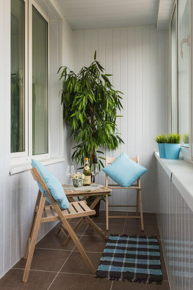 Saliekamie krēsli no koka uz silta balkona