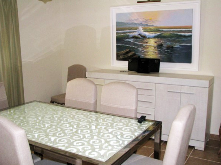 Par tradition, la salle à manger est décorée de peintures dans un cadre blanc comme neige.
