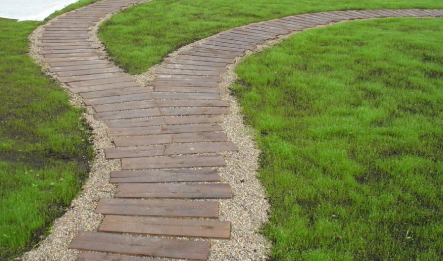 Wooden path through the lawn in the country