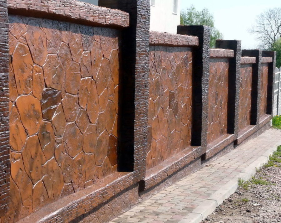 Di fronte a una recinzione in cemento con pietra naturale