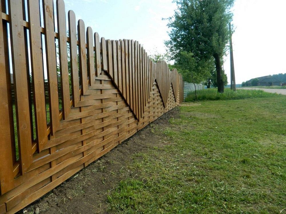 Trästaket av brädor med olika arrangemang av staket
