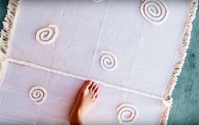 Můžete si vyrobit malý koberec, na kterém se bude příjemně stát s bosýma nohama. Ručně tkané pletené nebo tkané výrobky budou vypadat velmi roztomilé