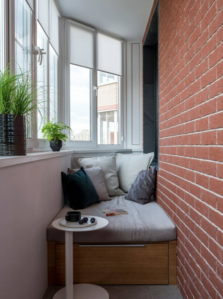 Sofá pequeno na varanda com acabamento em tijolo