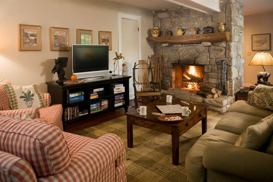 TV on a black cabinet in the living room with a wood-burning fireplace