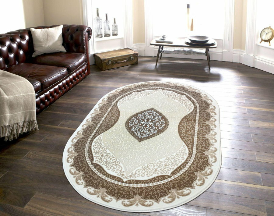 Põrandal ovaalne vaip, mis on valmistatud puitlaadsest laminaadist