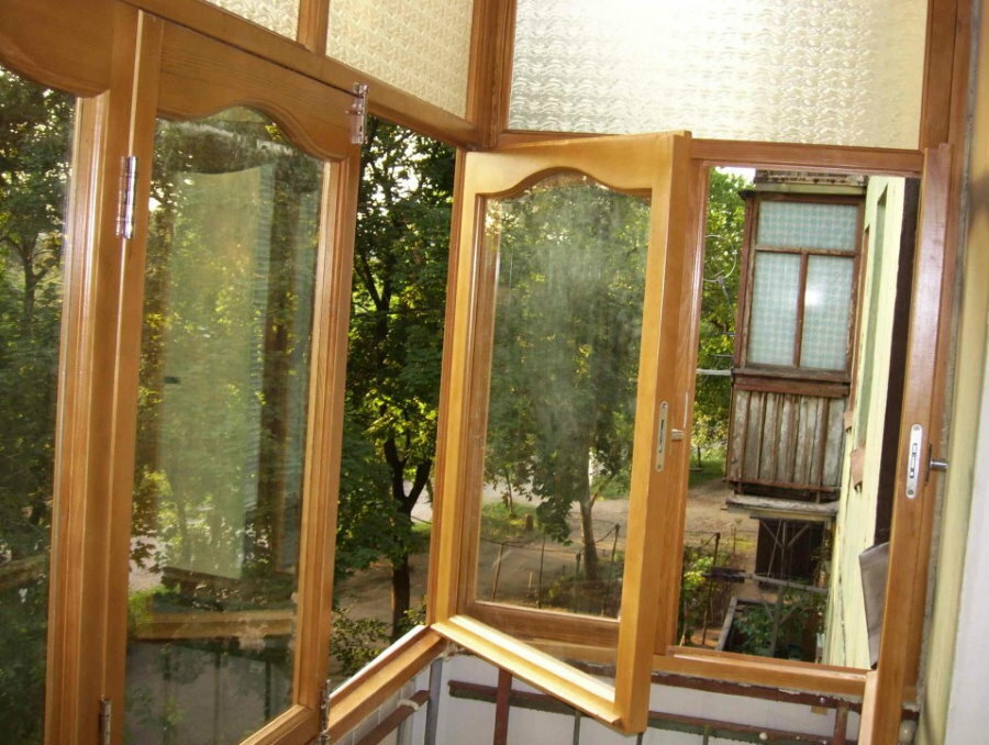 Open sashes of a wooden window on the balcony