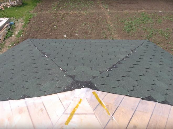 Zachte tegels op het dak van een zeshoekig tuinhuisje van hout