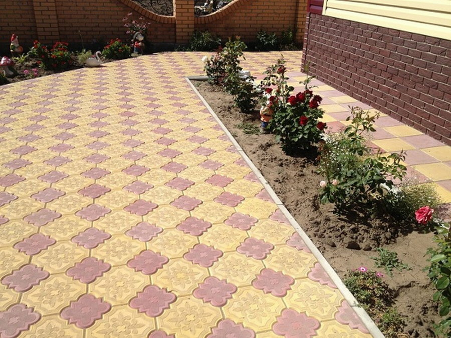 Chamomile paving slabs in front of a flower bed with roses