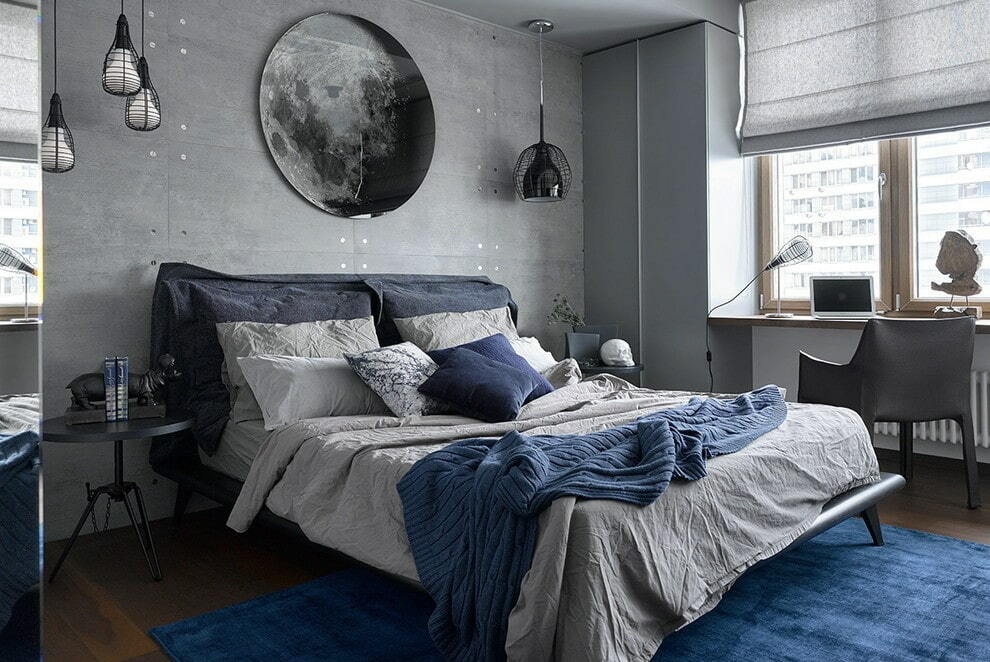 Niebieski dywan w sypialni z szarą tapetą