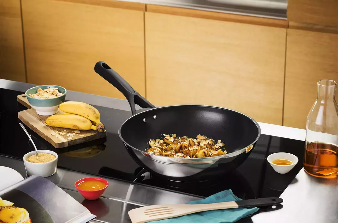 Sartén wok con comida en la estufa